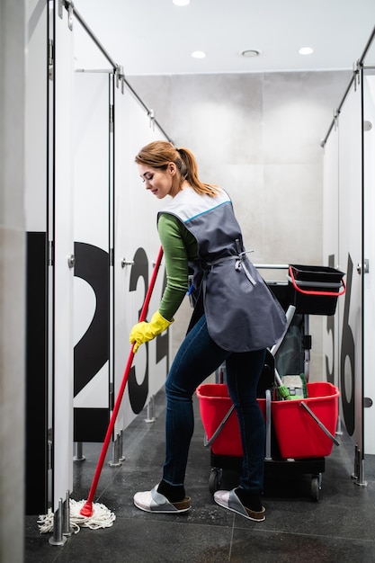 Beautiful young woman cleaning at shopping mall. Cleaning concept.