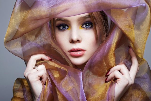 Красивая молодая женщина в цветной вуали красочная девушка макияжа
