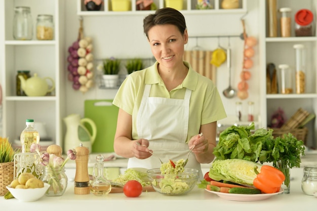 Beautiful young woman cooking in kitchen