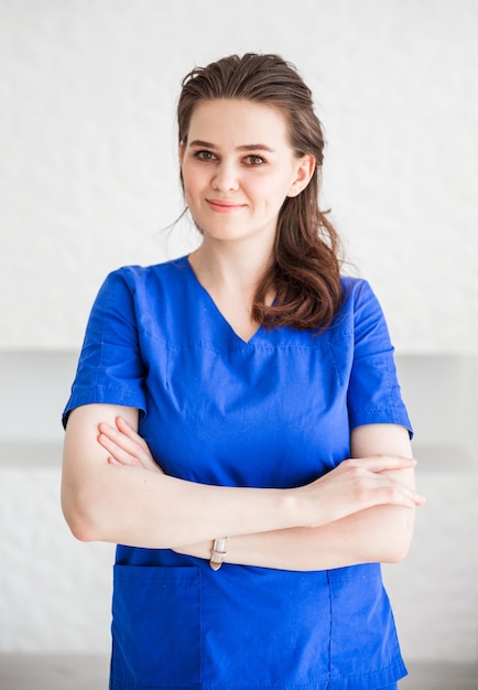 Beautiful young woman doctor posing in blue medical suit  .  