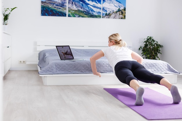 Beautiful young woman doing exercises at home