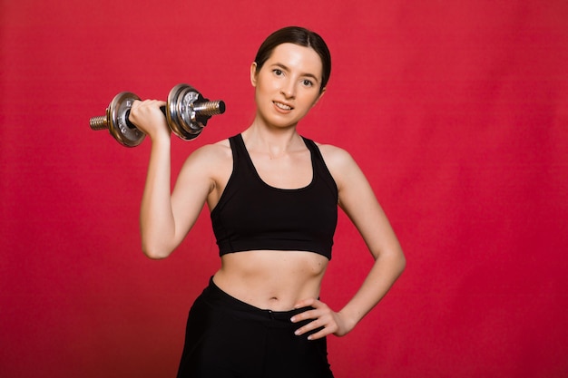 Beautiful young woman doing exercises with dumbbells