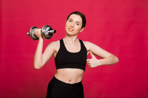 Beautiful young woman doing exercises with dumbbells