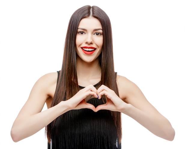 Photo beautiful young woman doing a heart shape with her hands