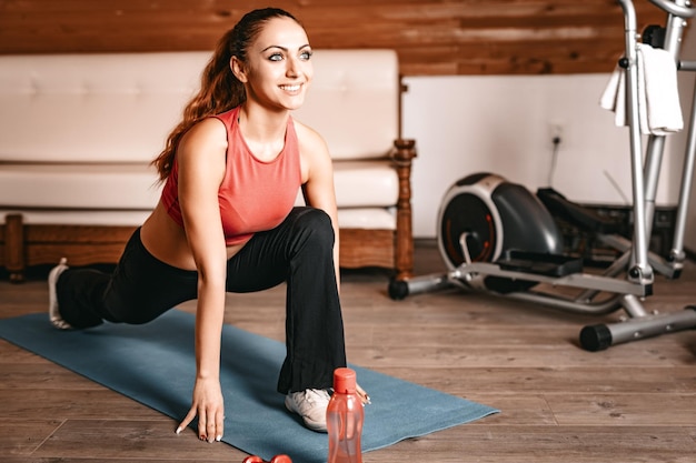 Beautiful young woman doing stretching exercises at home.