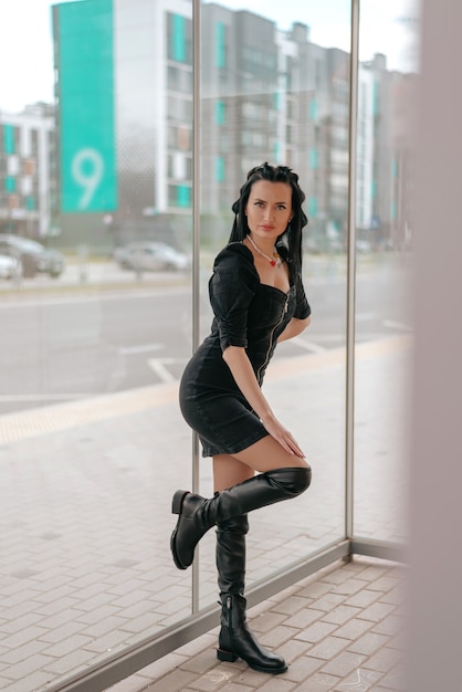 Beautiful young woman in dress posing at the bus stop with good weather