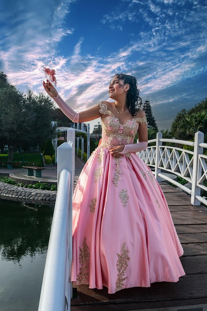 Beautiful young woman dressed as a princess posing on a bridge and beautiful landscape.