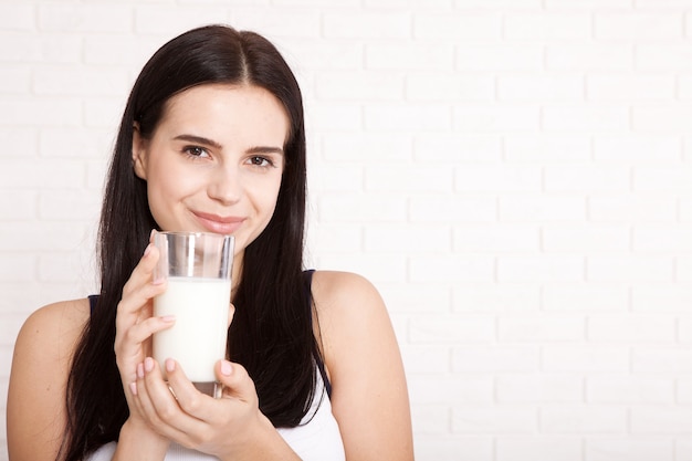 Beautiful young woman drinking milk at home