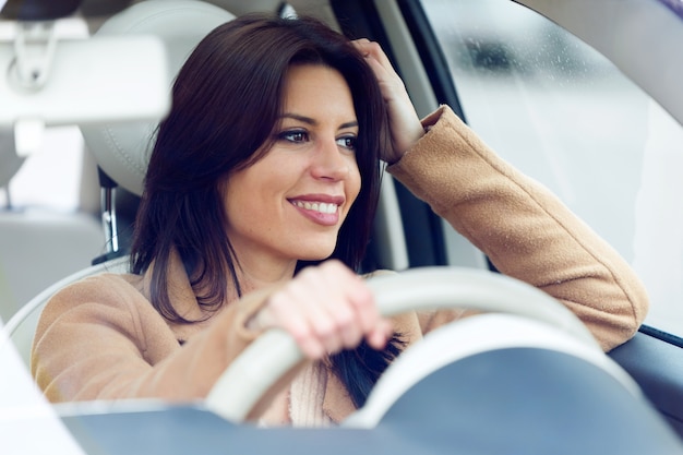 彼女の車を運転している美しい若い女性。