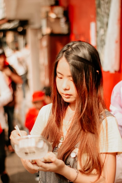 Beautiful young woman eating in city