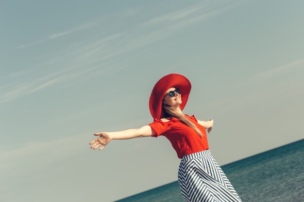 美しい若い女性は、ビーチで夏休みを楽しむ