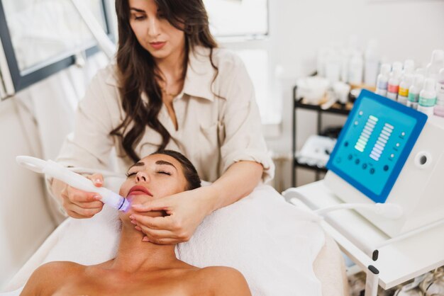 Beautiful young woman enjoying a hydrafacial treatment at the beauty salon.