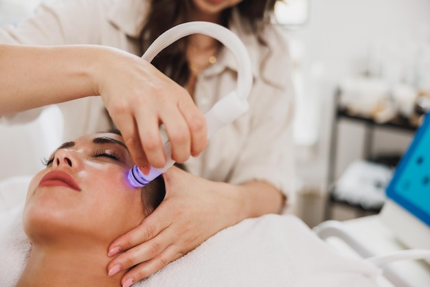 Foto bella giovane donna che gode di un trattamento idratante al salone di bellezza.