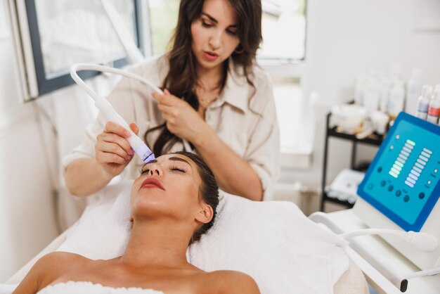 Beautiful young woman enjoying a hydrafacial treatment at the beauty salon.