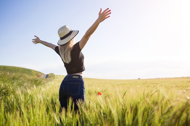 Beautiful young woman enjoying summer in a field.