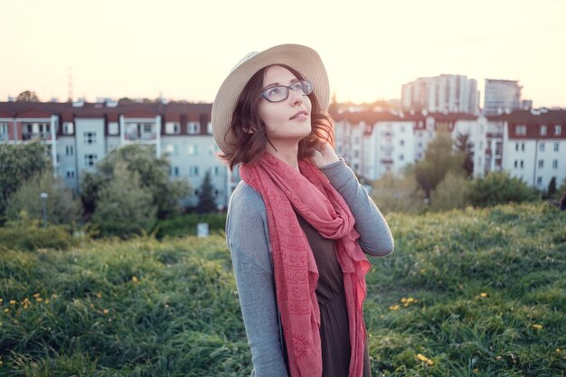 Beautiful young woman enjoying the sunset on top of a hill.