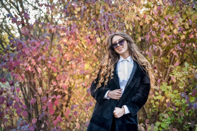 Beautiful young woman in a fur coat in the magical autumn forest.