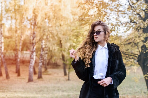 Beautiful young woman in a fur coat in the magical autumn forest.