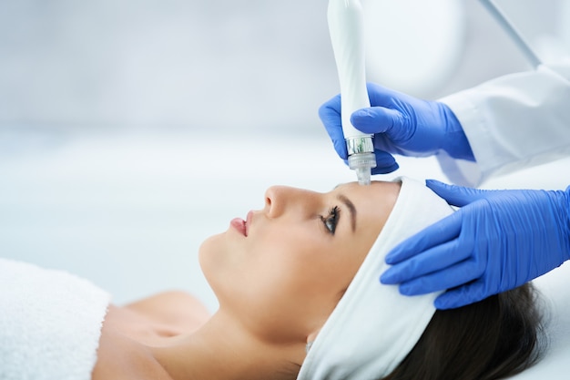 Beautiful young woman getting a face treatment at beauty salon.