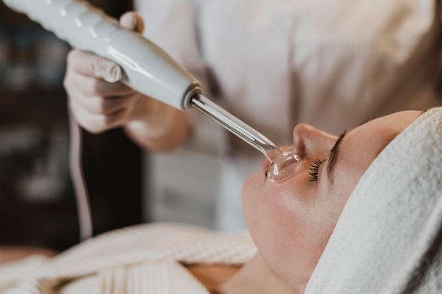 Photo beautiful young woman getting a facial treatment at the spa