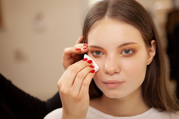 Beautiful young woman getting professional make-up done