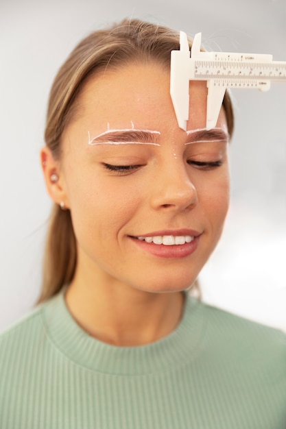 Foto bella giovane donna che si sottopone a un trattamento di microblading