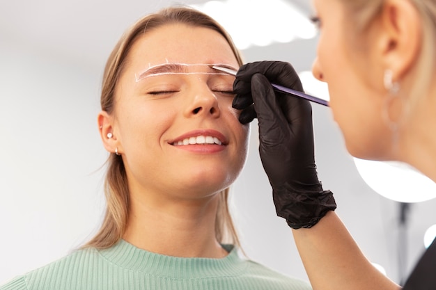 Bella giovane donna che si sottopone a un trattamento di microblading