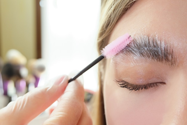 Beautiful young woman got correction of eyebrows in a beauty salon