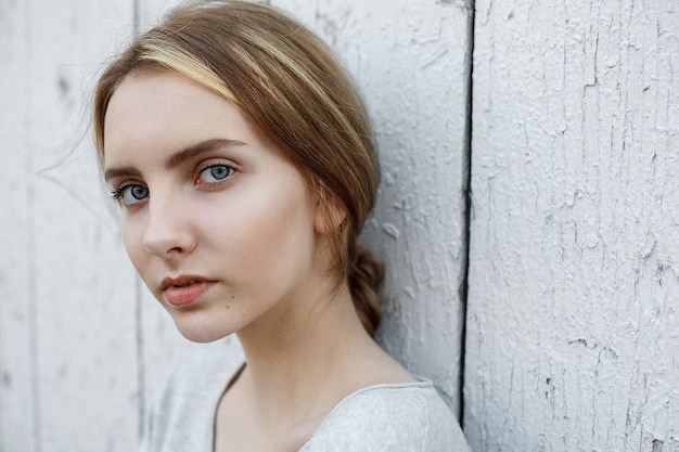 회색 블라우스에 아름 다운 젊은 여자, 귀여운 사려깊은 모델의 야외 초상화