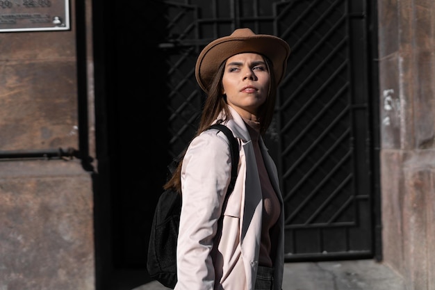 A beautiful young woman in a hat walks through the streets of the old city. Copy space