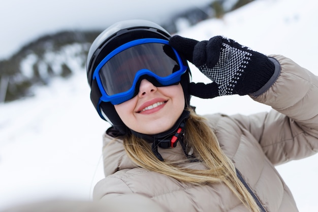 Beautiful young woman having fun over winter background.