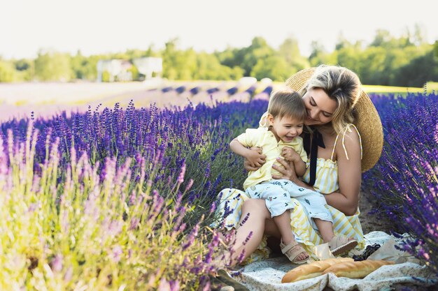 Bella giovane donna e il suo piccolo figlio carino nel campo di lavanda