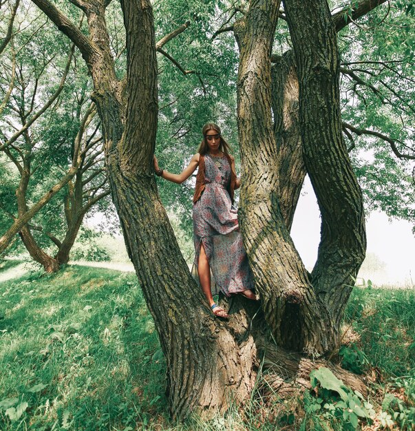 大きな木の近くの美しい若い女性のヒッピー