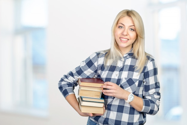 Beautiful young woman holding books