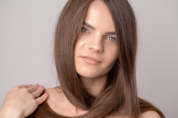 Beautiful young woman holding her healthy and shiny hair