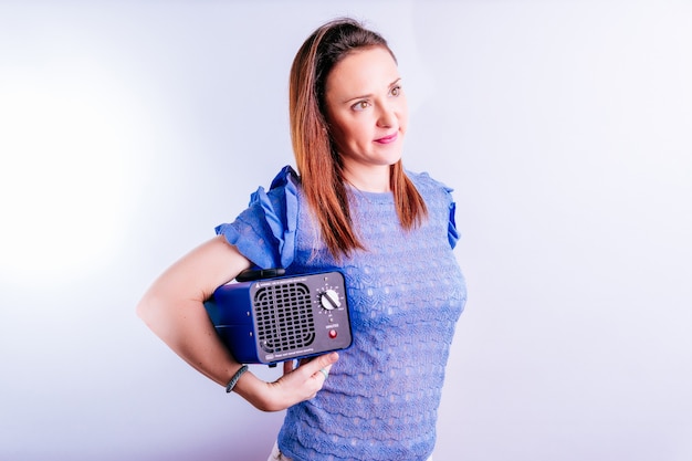 Beautiful young woman holding an ozone generating machine.\
disinfection concept on white background. covid 19. industrial\
equipment