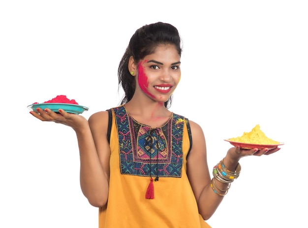 Красивая молодая женщина, держащая порошковый цвет в тарелке по случаю фестиваля Холи.