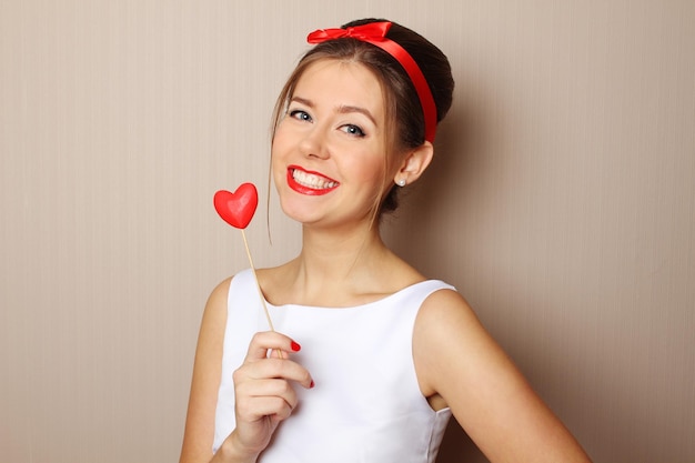 Beautiful young woman holding a red heart