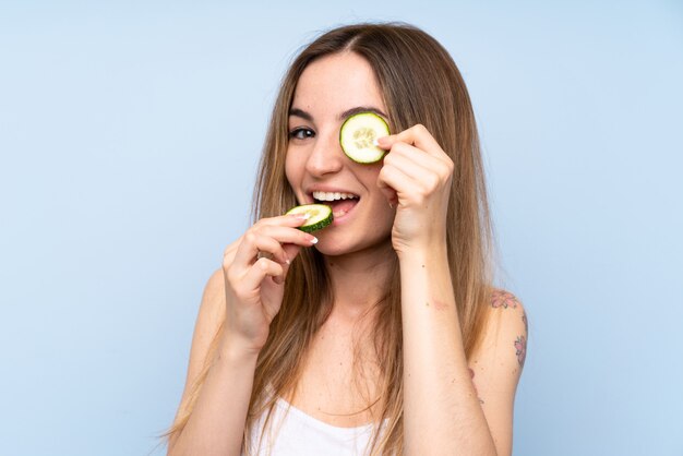 Beautiful young woman holding slices of cucumber