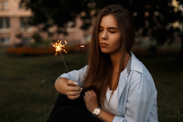 Beautiful young woman holding a sparkler