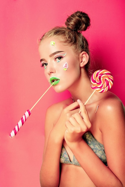 Photo beautiful young woman holds in hands candy smiling broadly