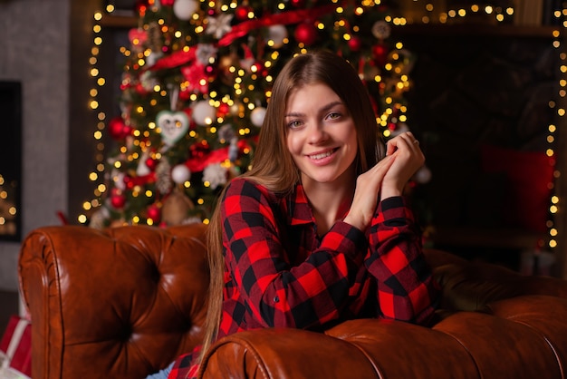 beautiful young woman at home in christmas with gifts near the christmas tree