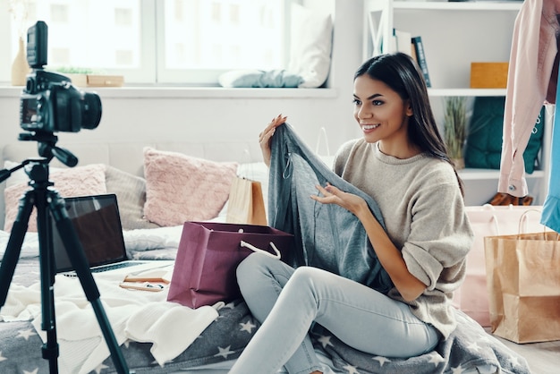 写真 自宅で時間を過ごしながらソーシャルメディアビデオを作るカジュアルな服装の美しい若い女性