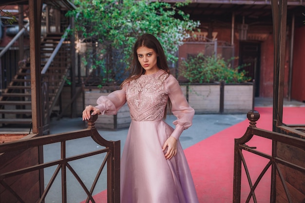 Beautiful young woman in a interesting dress posing in the art space Red October in Moscow Unusual stylish shooting for a catalog of designer clothes or a fashion magazine