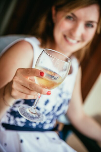 Beautiful young woman is enjoying a glass of wine in the holidays