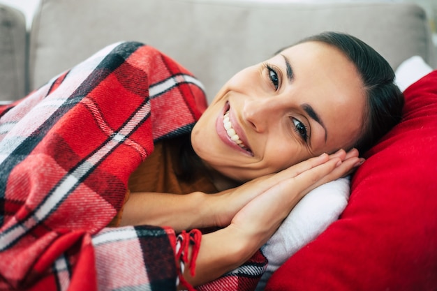 Beautiful young woman is lying on the couch