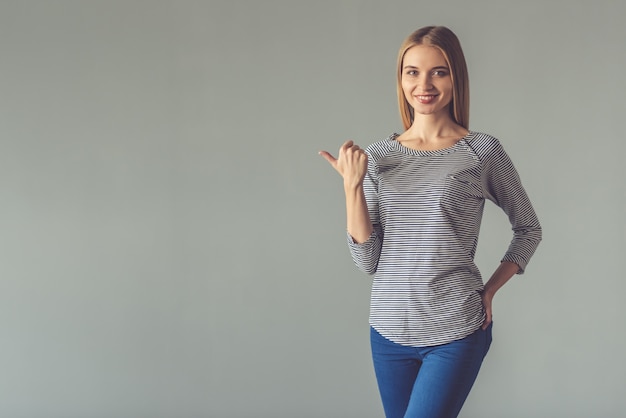 Beautiful young woman is pointing away