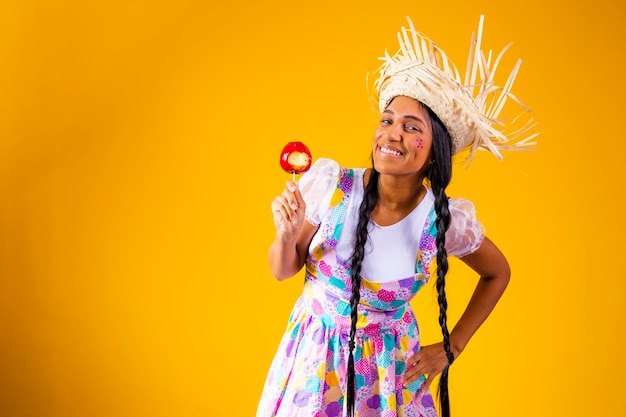 Beautiful young woman in June party clothes eating Love Apple Apple dessert covered in red caramel