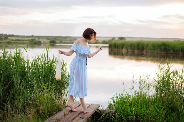 日没時の湖の美しい若い女性