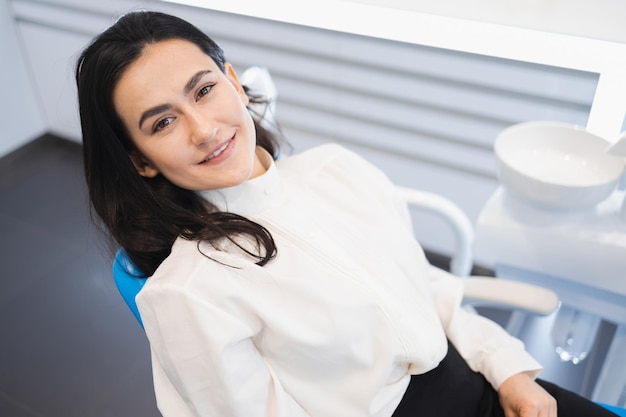 Foto la bella giovane donna si trova sulla sedia del dentista